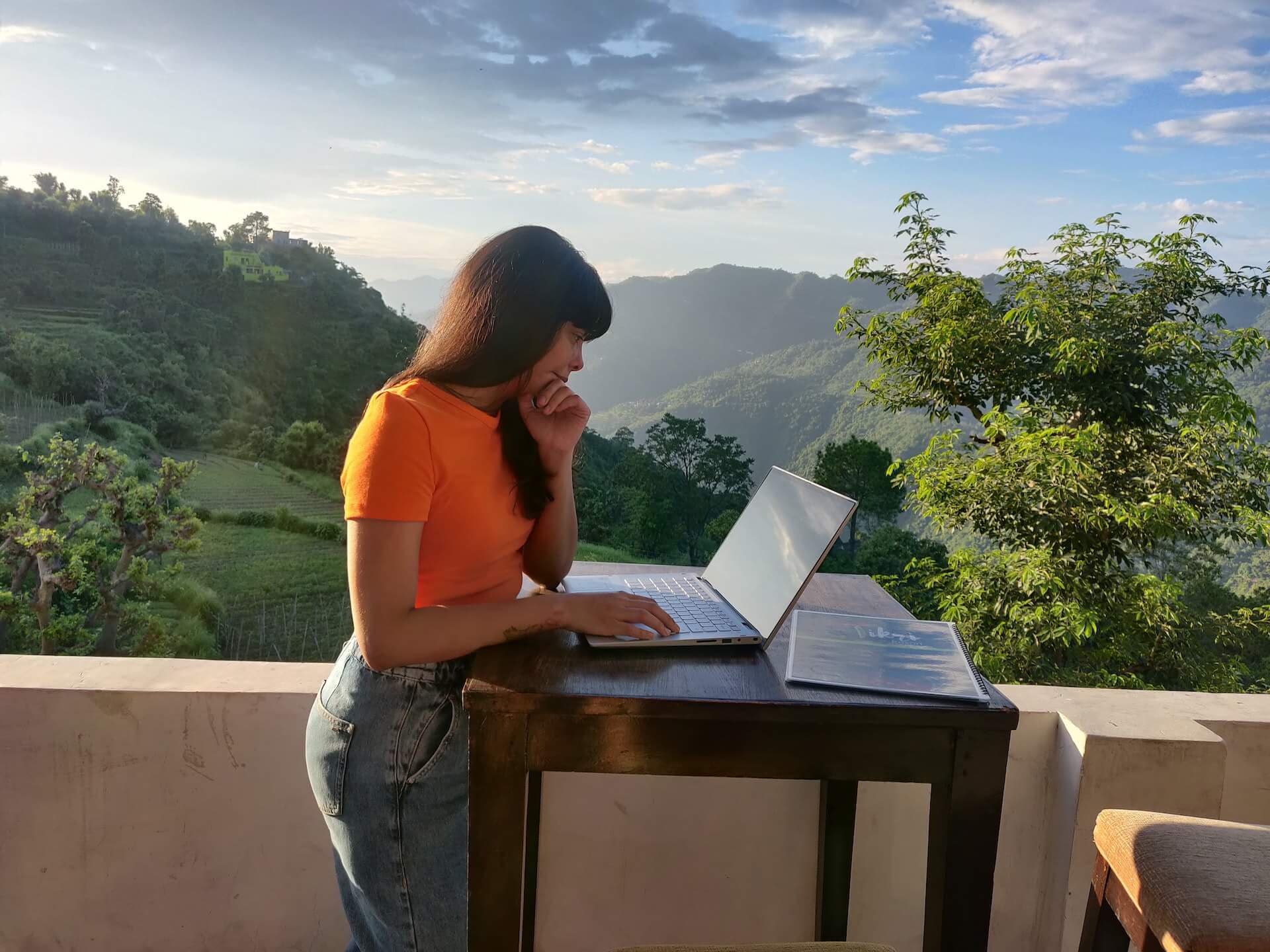 Person working remotely on a laptop looking out a window