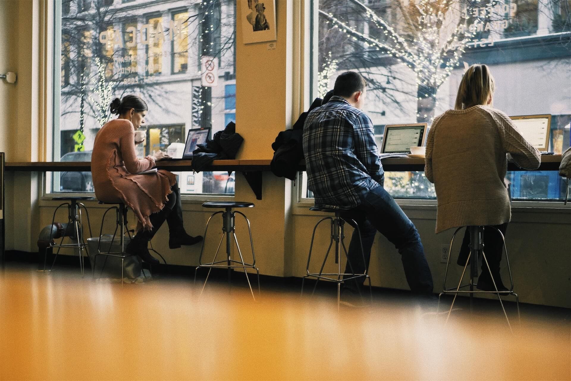 Person working remotely on a laptop looking out a window