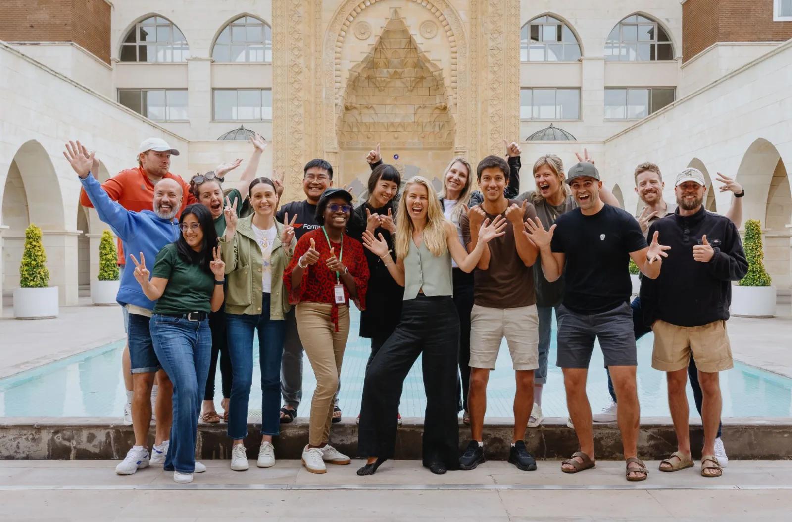 Members of the Buffer team smiling and waving together in a courtyard