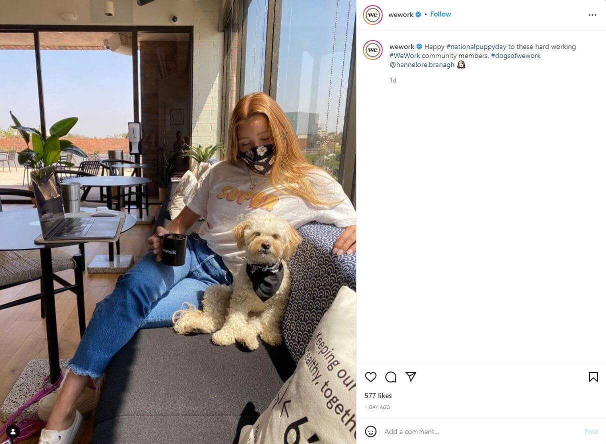 An image with a women sitting on a couch with a dog