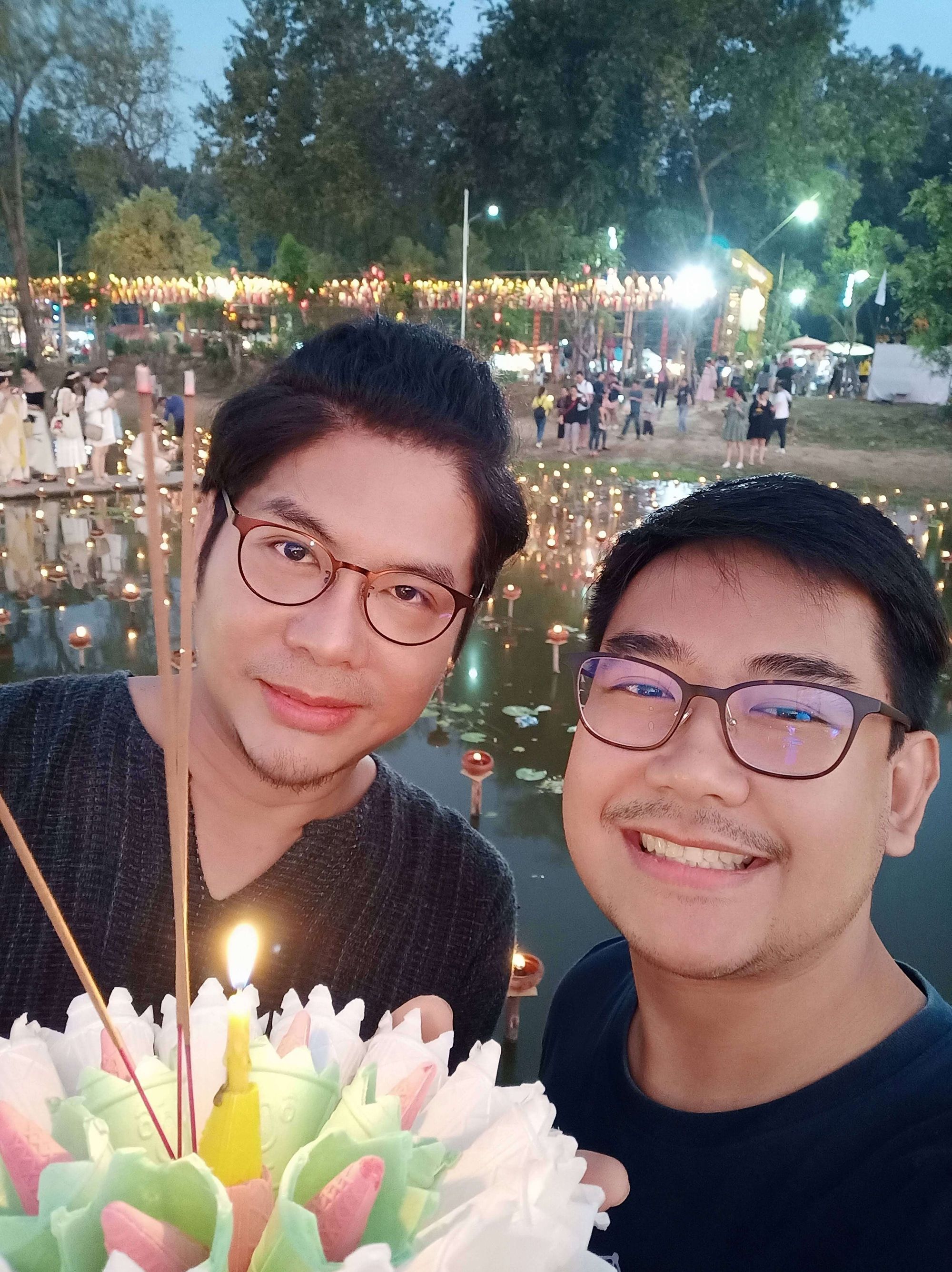 Dos personas sosteniendo un plato decorado iluminado por velas