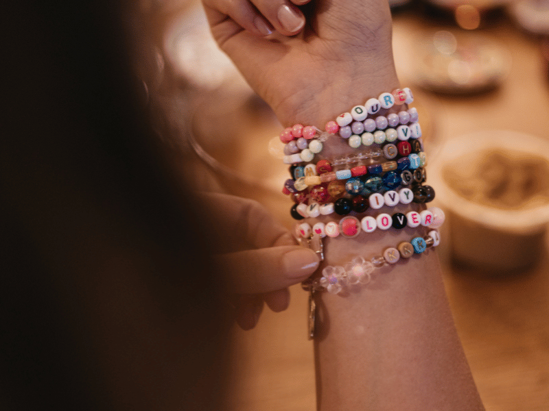 A woman sports a beaded bracelet like those worn at Taylor Swift's Eras Tour shows, a huge 2023 social media trend