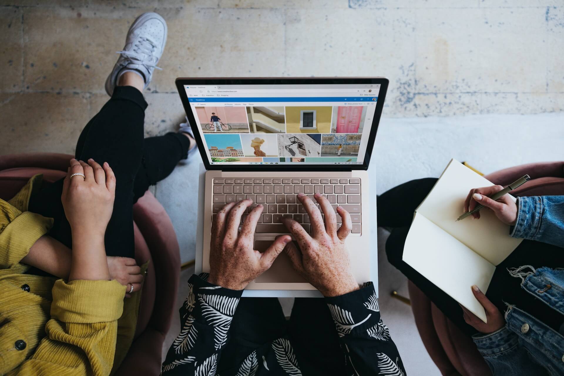 A top-down view of three people and a laptop as they explore good b2b content marketing.