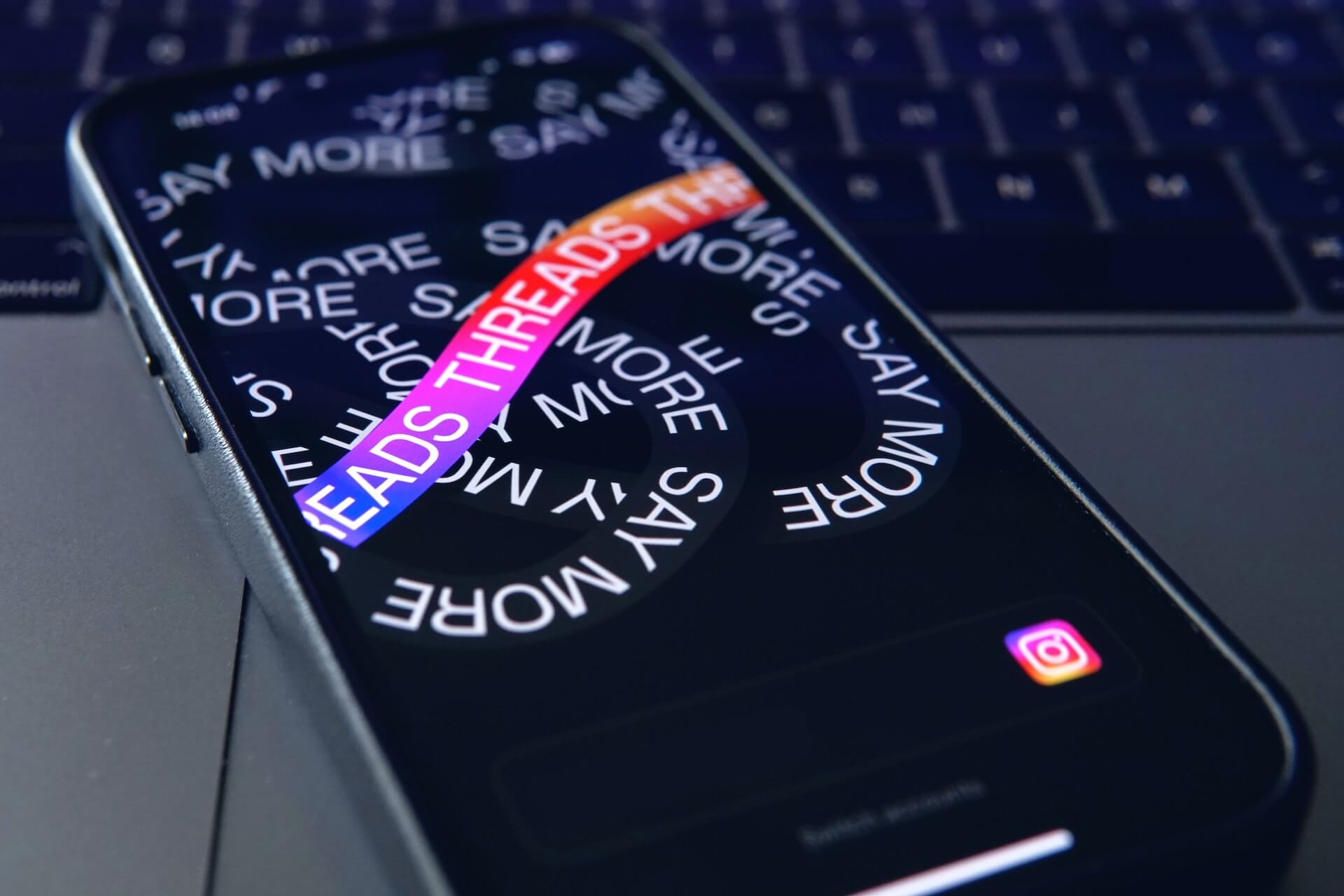 A photo of a phone displaying the Instagram threads logo. 