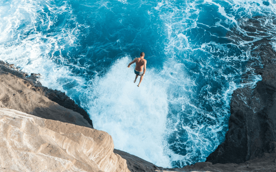 Man leaping into ocean from a cliff to illustrate leap day marketing campaigns