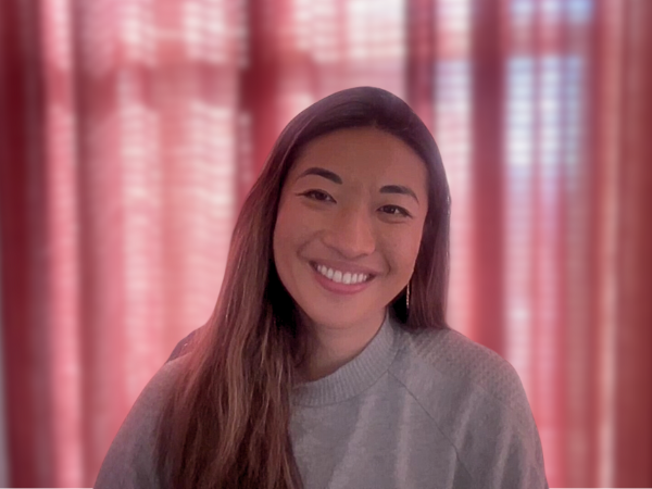 The COO of Bluesky, Rose Wang, sits in her home office with a pink curtain backdrop