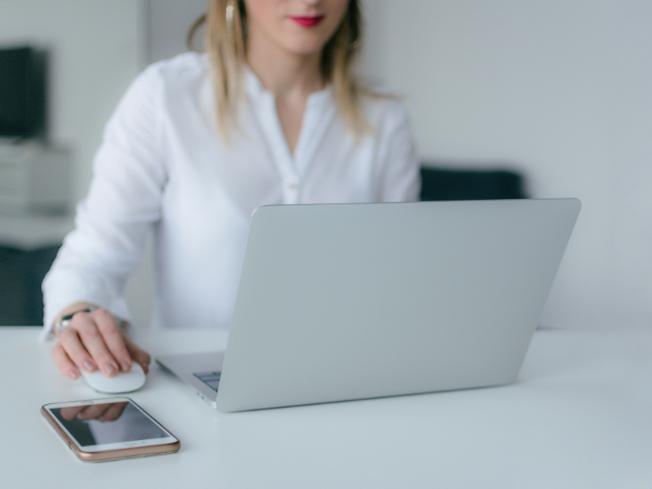 Woman using a macbook with a white mouse to illustrate finding the best URL shorteners