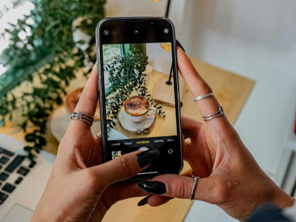 woman taking a photo of a cup of coffee to illustrate getting more followers on Pinterest