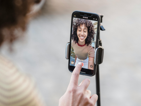 woman recording a video on her phone in selfie mode, to illustrate filming an unlockable reel on Instagram