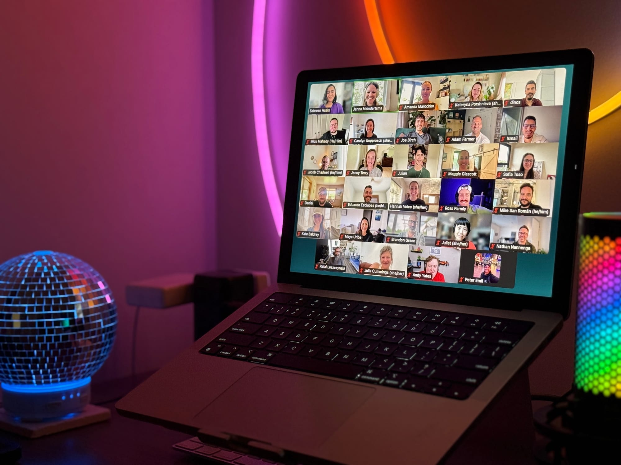 A Zoom grid view of Buffer teammates during the first Creator Café workshop, displayed on a laptop screen with colorful ambient lighting in the background.