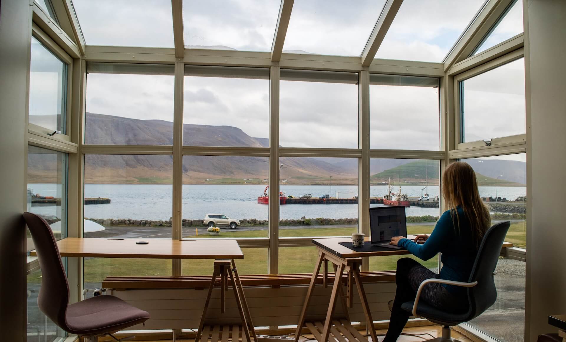 Person working remotely on a laptop looking out a window