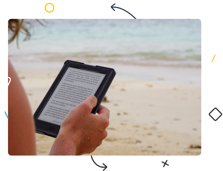 A person reading a Kindle on beach